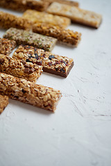 Image showing Row of mixed gluten free granola cereal energy bars. With dried fruits and nuts.