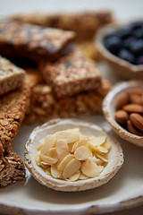 Image showing Close up of Almond petals. With various energy nutrition bars in background