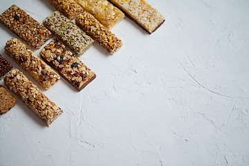 Image showing Row of mixed gluten free granola cereal energy bars. With dried fruits and nuts.