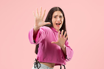 Image showing Portrait of the scared woman on pink