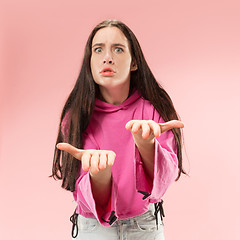 Image showing Beautiful female half-length portrait isolated on pink studio backgroud. The young emotional surprised woman