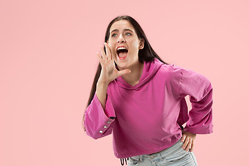 Image showing Isolated on pink young casual woman shouting at studio