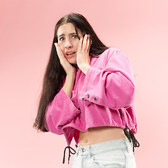 Image showing Portrait of the scared woman on pink