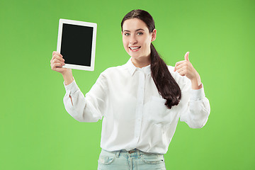 Image showing Portrait of a confident casual girl showing blank screen of laptop isolated over green background