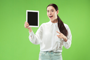 Image showing Portrait of a confident casual girl showing blank screen of laptop isolated over green background