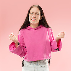 Image showing Beautiful female half-length portrait isolated on pink studio backgroud. The young emotional surprised woman