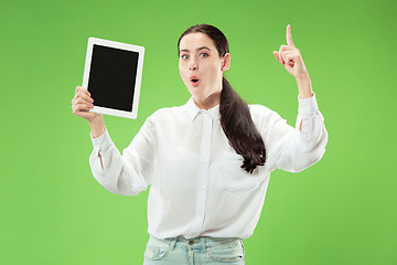 Image showing Portrait of a confident casual girl showing blank screen of laptop isolated over green background