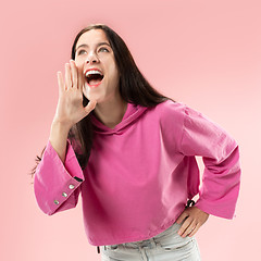 Image showing Isolated on pink young casual woman shouting at studio