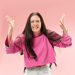 Image showing Beautiful female half-length portrait isolated on pink studio backgroud. The young emotional surprised woman