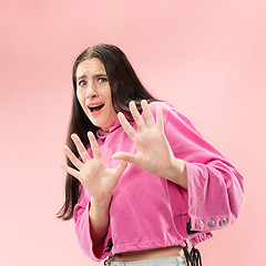 Image showing Portrait of the scared woman on pink