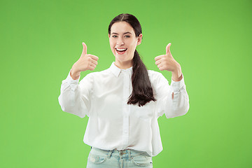 Image showing The happy business woman standing and smiling against green background.