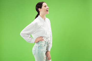 Image showing The happy business woman standing and smiling against green background.