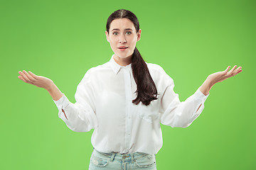 Image showing The happy business woman standing and smiling against green background.