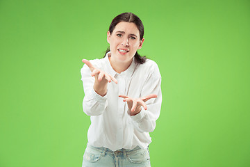 Image showing Beautiful woman looking suprised and bewildered isolated on green