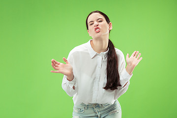 Image showing The squint eyed woman with weird expression isolated on green