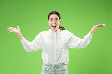 Image showing Beautiful woman looking suprised isolated on green