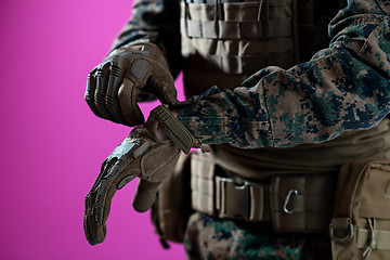 Image showing closeup of soldier hands putting protective battle gloves pink b