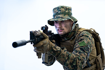 Image showing soldier in action aiming laseer sight optics