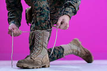 Image showing soldier tying the laces on his boots