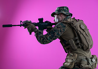 Image showing soldier in action aiming laseer sight optics pink background