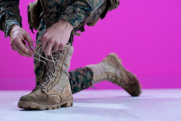 Image showing soldier tying the laces on his boots