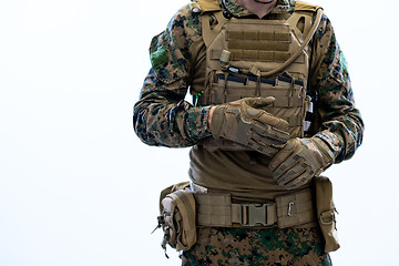 Image showing closeup of soldier hands putting protective battle gloves