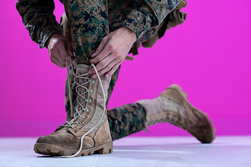 Image showing soldier tying the laces on his boots