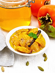 Image showing Persimmons baked with honey in dish on white board