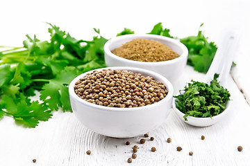 Image showing Coriander ground and seeds in bowls on light board