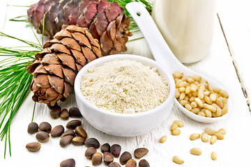 Image showing Flour cedar in bowl and nuts in spoon on board