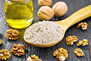 Image showing Flour walnut in spoon with oil on dark board