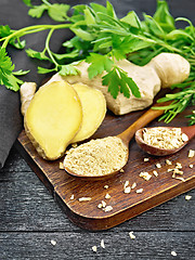 Image showing Ginger ground and flakes in spoons on wooden board