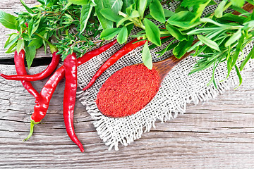 Image showing Peppers red powder in wooden spoon on board top