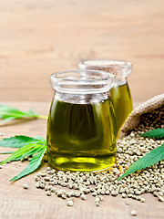 Image showing Oil hemp in two jars with sheet on board