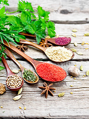 Image showing Spices in spoons on old wooden board