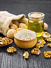 Image showing Flour walnut in bowl on dark wooden board
