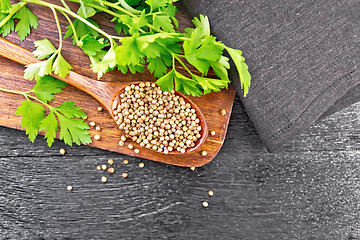 Image showing Coriander seeds in spoon on black board top