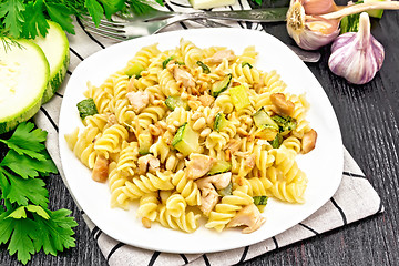 Image showing Fusilli with chicken and zucchini in plate on dark wooden board