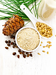 Image showing Flour cedar in bowl and nuts in spoon on white board top