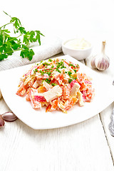 Image showing Salad of surimi and tomatoes with mayonnaise on wooden board