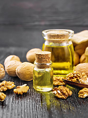 Image showing Oil walnut in two jars on wooden board