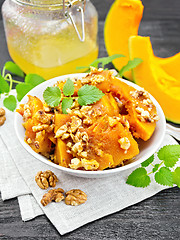 Image showing Pumpkin with nuts and honey on dark board