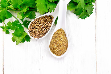 Image showing Coriander ground and seeds in two spoons on white board top