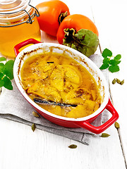 Image showing Persimmons baked with honey in pan on white board