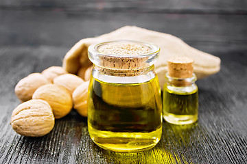 Image showing Oil walnut in jar and bottle on board