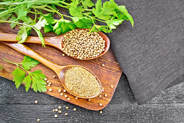 Image showing Coriander ground and seeds in two spoons on black board top