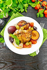 Image showing Chicken with fruits and tomatoes in plate on dark board top