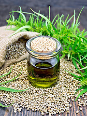 Image showing Oil hemp in jar with seed on dark board