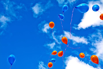 Image showing Balloons orange and blue in sky with clouds