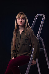 Image showing Psychological portrait of a girl sitting on a ladder